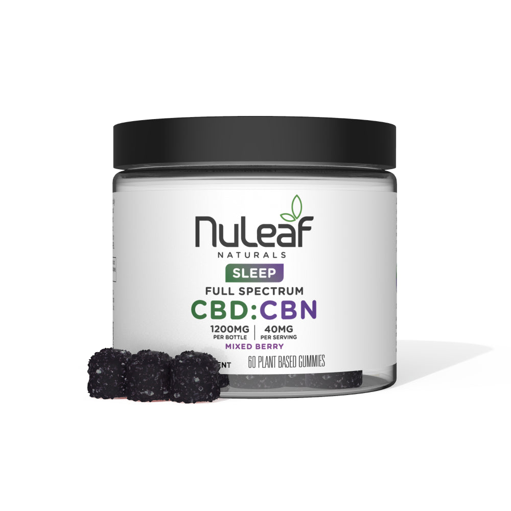 A clear wide-mouth jar with a black lid containing NuLeaf Naturals Sleep Full Spectrum CBD:CBN Hemp Supplement Gummies (1200mg per bottle, 40mg per serving, Mixed Berry flavor, 60 plant-based gummies) with two dark purple mixed berry gummies displayed in front, shown against a clean white background.