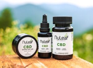 NuLeaf CBD balm, oil and capsules on a table 