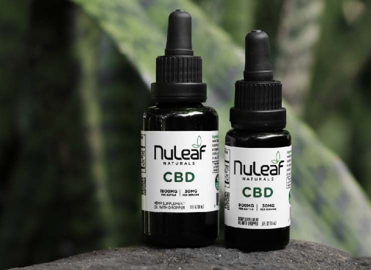 two bottles of nuleaf cbd oil with a plant in background